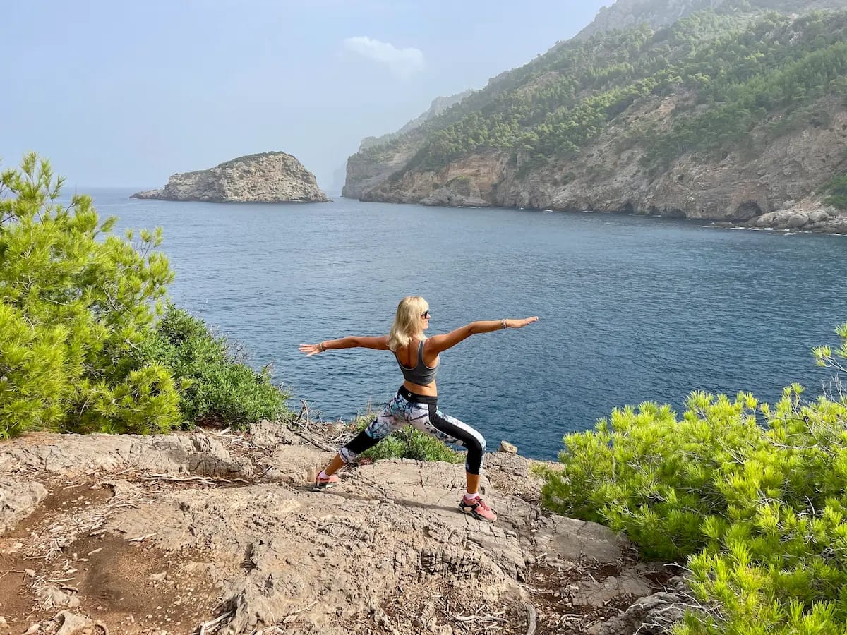 Yoga retreat Mallorca 2026 — Jana practicing warrior pose on coastal cliffs Tramuntana